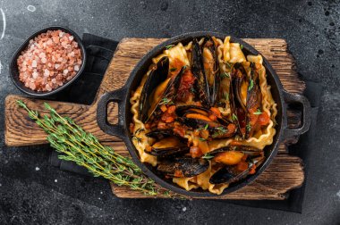 Midye ve domates soslu Mafaldine makarnası. Siyah arka plan. Üst görünüm