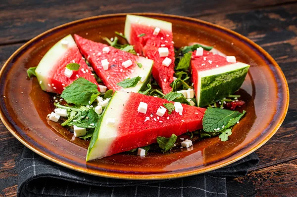 Frisse zomer watermeloen salade met feta kaas, arugula, uien in een rustieke plaat. Donkere achtergrond. Bovenaanzicht — Stockfoto