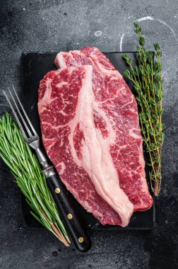 Çiğ Striploin bifteği ya da New York bifteği kesimi. Siyah arka plan. Üst görünüm