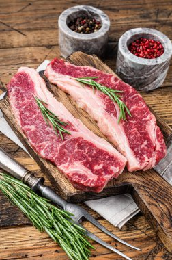Prime Black Angus bifteği, Raw Striploin veya New York. Ahşap arka plan. Üst görünüm