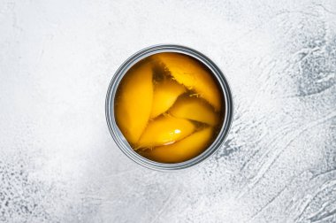 Metal bir teneke kutuda şerbete konserve mango dilimleri. Beyaz arka plan. Üst görünüm