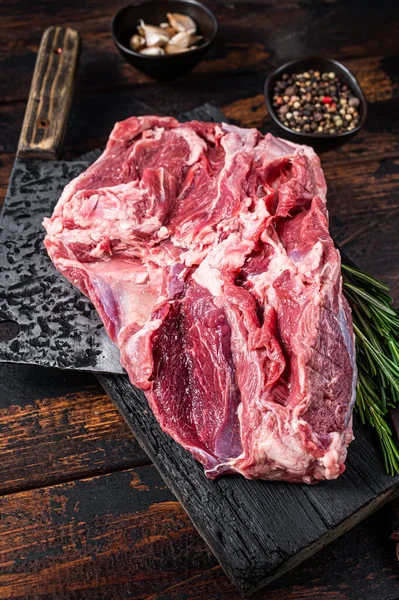 Boneless raw Leg of mutton Lamb meat on butcher cutting board with cleaver. Dark wooden background. Top view — Stock Photo, Image