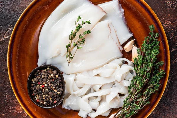 In Scheiben geschnittene Calamari-Ringe in einem rustikalen Teller mit Rosmarin. Dunkler Hintergrund. Ansicht von oben — Stockfoto