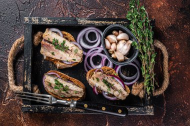 Sardalya, sardalya, krem peynir ve soğanlı tapas. Karanlık arka plan. Üst görünüm