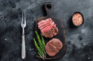 Biftek fileto mignon fileto ızgara ve dilimlenmiş biftek. Siyah arka plan. Üst görünüm