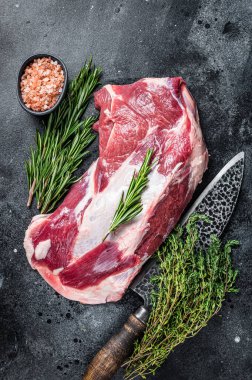 Taze çiğ kuzu eti ya da kasap bıçağıyla keçi omzu eti. Siyah arka plan. Üst görünüm