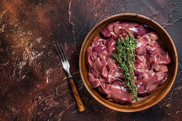 Raw chicken liver offals in a wooden plate. Dark background. Top view. Copy space — Stock Photo, Image