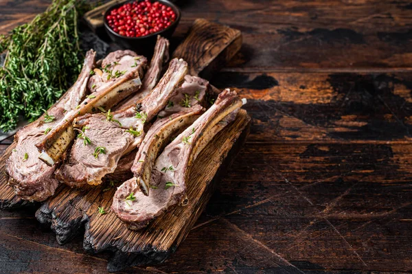 Churrasco costelas de cordeiro grelhado costeletas bifes no talho bordo com cutelo de carne. Fundo de madeira escuro. Vista superior. Espaço de cópia — Fotografia de Stock