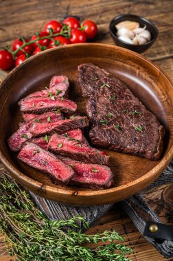 Ahşap bir tabakta dilimlenmiş üst bıçak ya da Denver bifteği. Ahşap arka plan. Üst görünüm