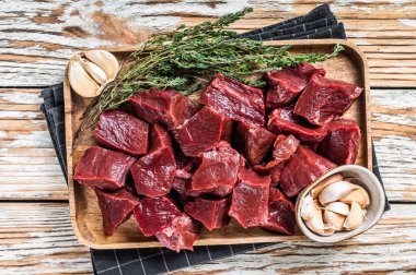 Çiğ sığır eti ya da ahşap tepside kekikli dana kalbi. Beyaz ahşap arka plan. Üst Görünüm