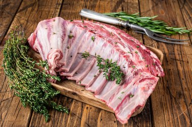 Ahşap tepside otlu kuzu pirzola rafı. Ahşap arka plan. Üst görünüm