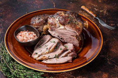 Barbekü rostosu, kuzu budu. Kırsal bir tabakta dilimlenmiş. Karanlık arka plan. Üst görünüm