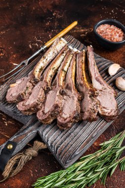 Ahşap tahtada ızgara kuzu pirzola bifteği. Karanlık arka plan. Üst görünüm