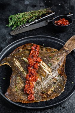 Kızarmış Flatfish veya domates soslu Flounder. Siyah arka plan. Üst görünüm