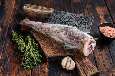 Taze çiğ morina ya da tahta tahtada satırla morina balığı. Karanlık ahşap arka plan. Üst görünüm