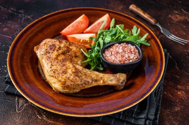 Kümes hayvanları tabağı. Kızarmış tavuk bacağı ve sebze salatası. Karanlık arka plan. Üst görünüm