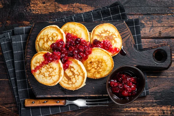 Tumpukan pancake sirup cranberry di papan kayu. Latar belakang kayu gelap. Tampilan Atas — Stok Foto