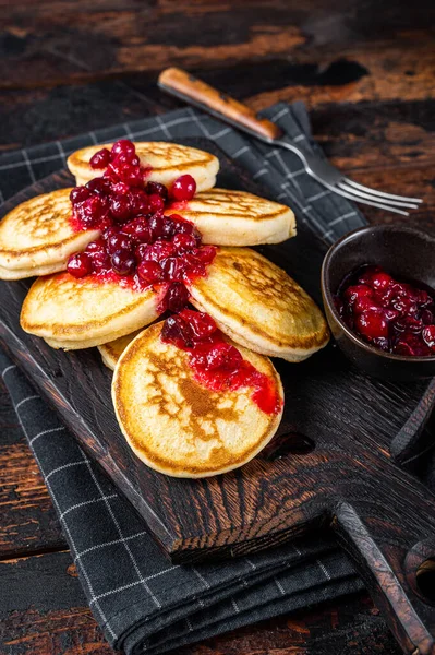 Stapelweise Preiselbeersirup-Pfannkuchen auf Holzbrettern. Dunkler Holzhintergrund. Ansicht von oben — Stockfoto