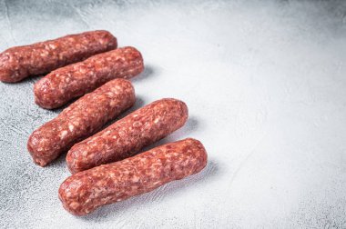 Kasap masasında çiğ et ve kuzu eti kebabı sosis. Beyaz arka plan. Üst Manzara. Boşluğu kopyala