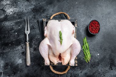 Ahşap tepside bütün bir tavuk çiftliği. Siyah arka plan. Üst görünüm