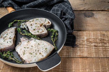 Taze çiğ kurt fileto bifteği ve otlarla dolu bir tavada. Ahşap arka plan. Üst Manzara. Boşluğu kopyala