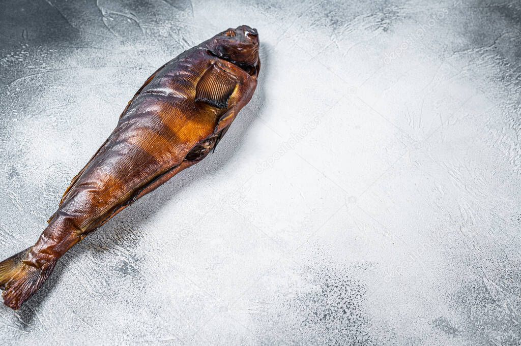 Hot smoked whole fish on kitchen table. White background. Top view. Copy space