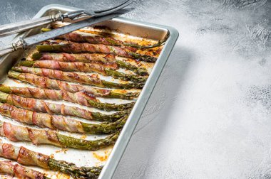 Pastırmaya sarılmış kuşkonmaz ve barbekü tepsisi. Beyaz arka plan. Üst Manzara. Boşluğu kopyala