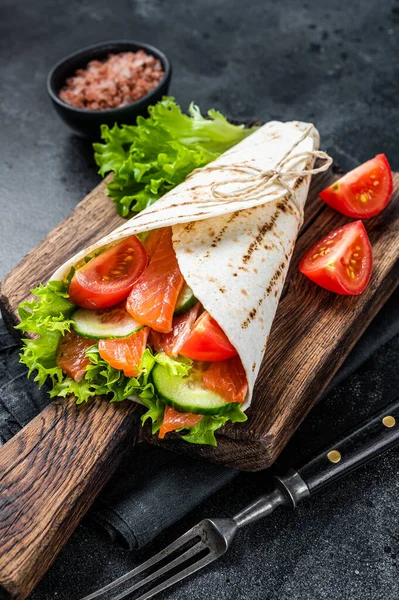 Tortilla Wrap laxrulle med sallad, grönsaker. Svart bakgrund. Ovanifrån — Stockfoto