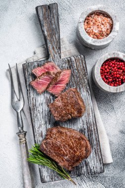 Kızarmış fileto mignon ya da ahşap kesme tahtasında bonfile biftek. Beyaz arka plan. Üst görünüm