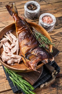 Tütsülenmiş balık filetosu ya da ahşap bir tabakta otlarla zander. Ahşap arka plan. Üst görünüm