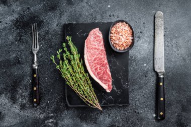 Wagyu çiğ sığır filetosu, mermer tahtada kobe bifteği. Siyah arka plan. Üst görünüm