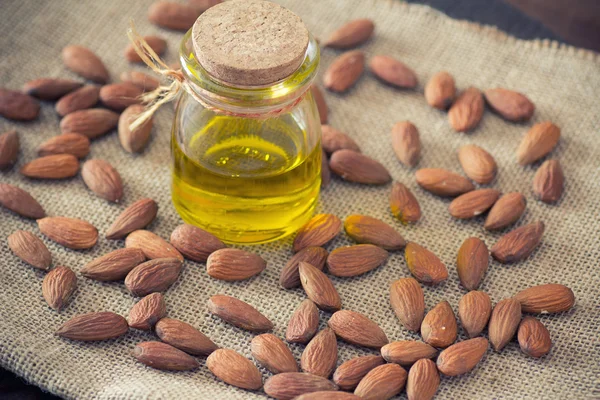 Fresh almond oil on wooden table — Stock Photo, Image