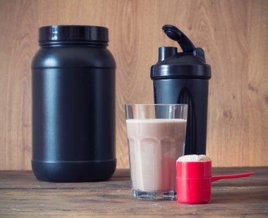 Peynir altı suyu protein tozu kepçe ve ahşap arka plan üzerinde plastik shaker