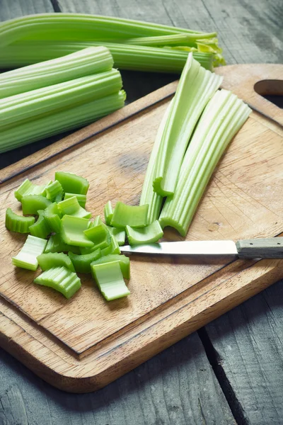 Frisch grüne Selleriestämme auf einem Holzschneidebrett in Nahaufnahme — Stockfoto