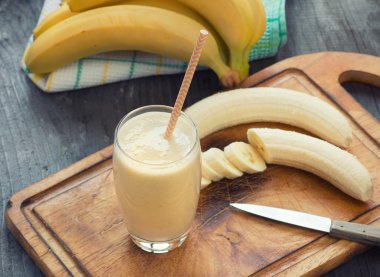 Taze muz smoothie üzerinde ahşap arka plan yaptı.
