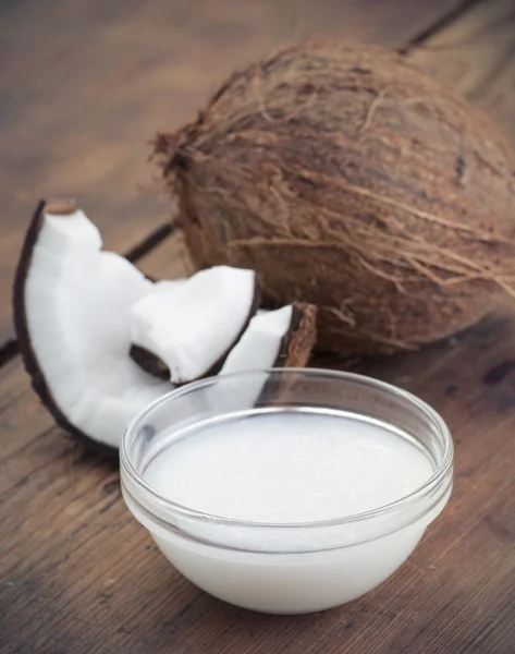 Coconuts and organic coconut oil in a glass jar — Stock Photo, Image