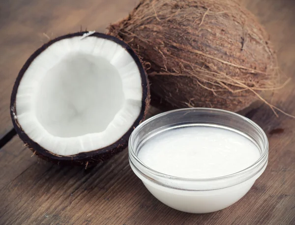 Kokosnoten en biologische kokosnoot olie in een glazen pot — Stockfoto