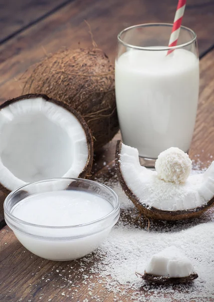 Aceite de coco, copos de coco molidos, leche de coco y dulces de coco — Foto de Stock