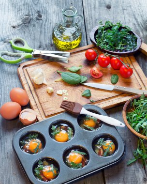 Ahşap arka plan üzerinde kahverengi plaka üzerinde taze yeşil ıspanak demet