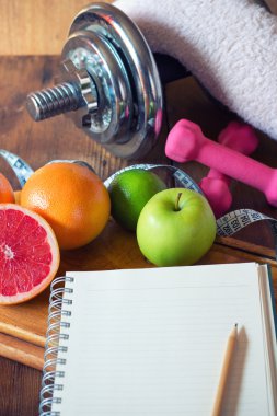Diyet planı. diyet planı ve bir meyve ve bir ahşap yüzeye yalan halter
