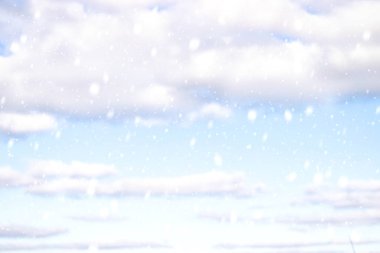 Mavi bulutların arka planında kar yağan kış manzarası. Kış gökyüzü