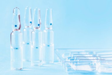 Ampul ambalajının yanındaki masada tıbbi ampuller var. Tıbbi cam ampulleri yakın plan..