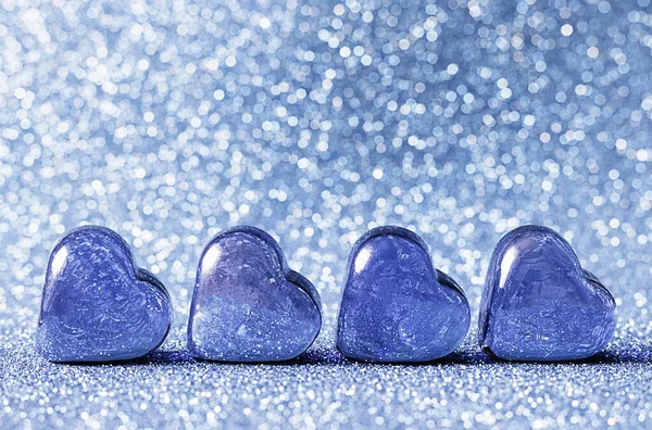 Glass blue hearts on a blue background. Concepts of valentines day card, wedding and invitation. Place for your text.