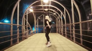 Genç kadın geceleri açık havada modern gençlik dansı kompozisyonu ile dans ediyor. Profesyonel hip hop, serbest stil veya havalı dansçı.