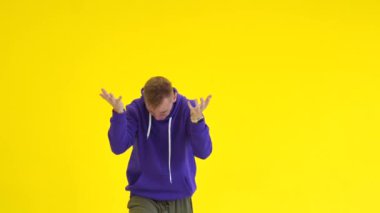 Hip hop dansı yapan adam, stüdyoda sarı bir duvara karşı modern koreografi. İzole edilmiş. Orta uzunlukta.