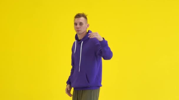 彼はヒップホップを踊っている 黄色の壁に対してスタジオで現代的な振付 隔離されてる 中ロングショット — ストック動画
