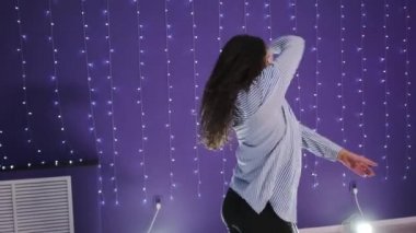 Modern dans eden genç bir kadın, koreografi stüdyosunda plastikleri soyuyor. Yavaş çekim.