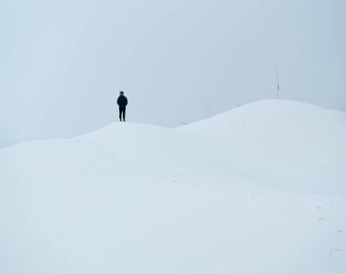 Nepal 'de, Makalu Ulusal Parkı' nda kar beyazı bir dağın tepesinde duran bir adam.