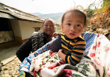 Anapurna, Nepal 'e gidiyorum. 11 / 01 / 2018. Sepette oturan ve kameraya bakan Nepalli kız.