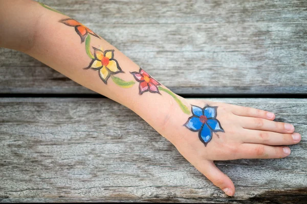 Picture of flowers on the child's hand. Old wood background.